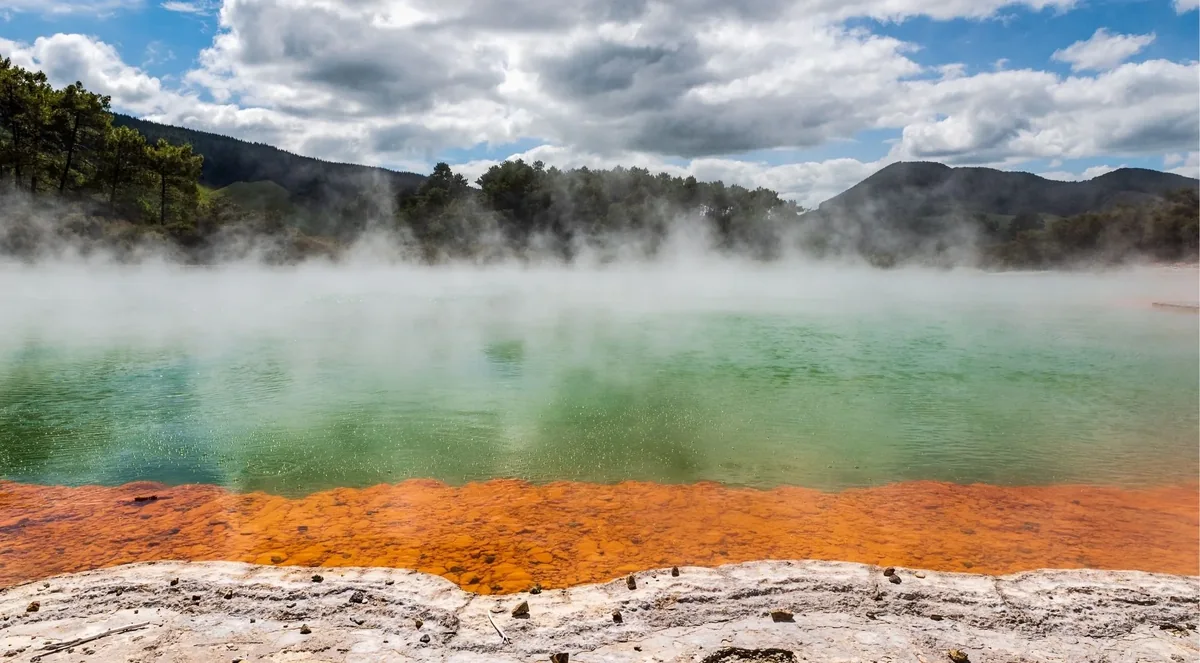 Steam above Champagne Pool and its orange mineral rim at Wai-O-Tapu
